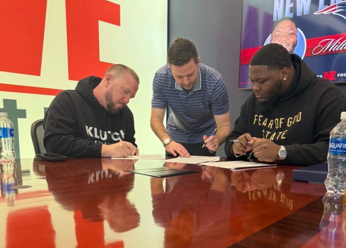 Rick Roberts at the signing table representing an athlete on a New England Patriots contract.